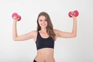 bela jovem fazendo exercícios físicos com halteres foto