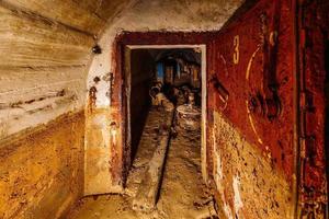 Porta blindada de metal enferrujado em antigo bunker soviético sujo e abandonado foto