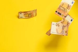 chuva de notas de euro, dinheiro caindo voando sobre um fundo amarelo, foto