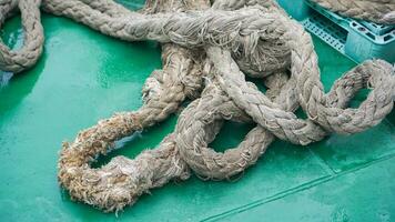 amarração corda em solo, equipamento em barco para estacionamento dentro a porta, naval corda branco cor em bobina. foto