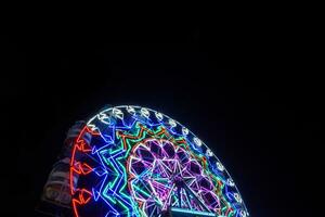 borrão movimento do luz ferris roda. grandes exposição luz às noite Diversão parque, alegre ir em volta. foto