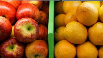 vermelho maçãs e laranjas lado de lado dentro a fazer compras e mercado. contraste cor conceito foto