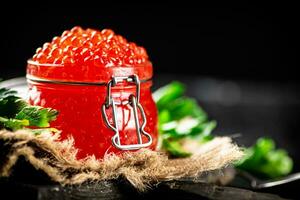 vermelho caviar em uma corte borda com salsinha. foto