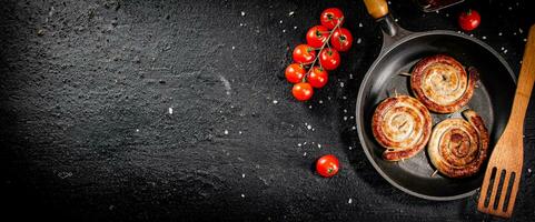 delicioso grelhado salsichas dentro uma fritar panela com fresco tomates. foto