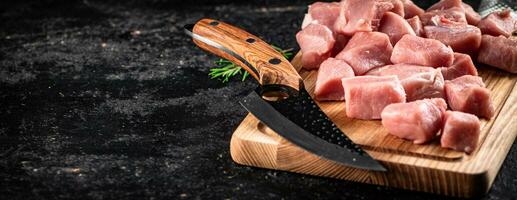 peças do cru carne de porco em uma de madeira corte borda com uma faca. foto