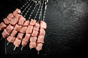 carne de porco Kebab cru em espetos em uma pedra borda. foto