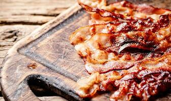 frito bacon em uma corte borda. foto