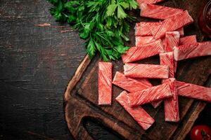 caranguejo carne em uma corte borda com verdes. foto