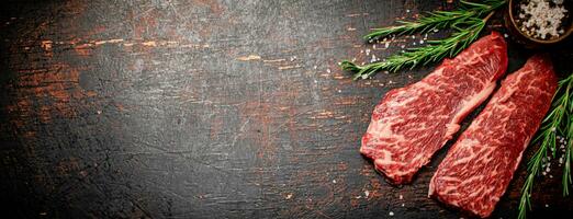 cru bife com alecrim e especiarias em a mesa. foto