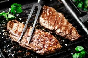 grelhado bife com salsinha dentro uma fritar frigideira. foto