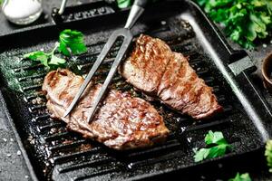 grelhado bife com salsinha dentro uma fritar frigideira. foto