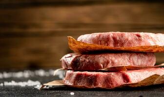 pilha cru hamburguer em a mesa. foto