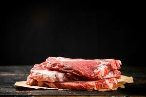 uma pilha do cru carne de porco bife em a mesa. foto