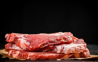 uma pilha do cru carne de porco bife em a mesa. foto