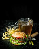 hamburguer com cerveja, fritas e pepinos. foto