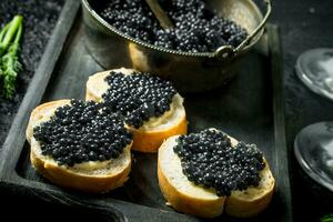 sanduíches com Preto caviar em a corte borda. foto