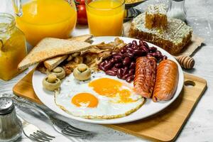 Inglês café da manhã. uma variedade do lanches com laranja suco. foto