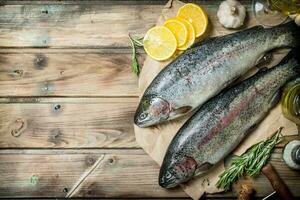 cru mar peixe salmão em velho papel com limão fatias e perfumado alecrim. foto