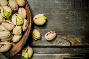 pistachios dentro uma de madeira colher. foto