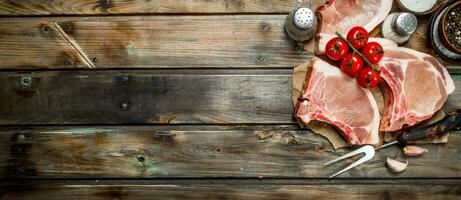 cru carne de porco bifes com tomates e especiarias. foto