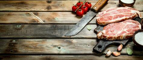 cru carne de porco bifes com tomates e especiarias. foto