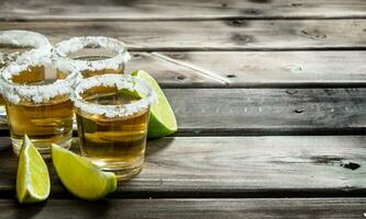 tequila dentro uma tiro vidro com Lima fatias. foto