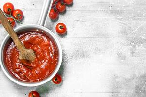 tomate molho dentro uma Panela com fresco tomates. foto