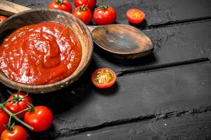 tomate molho dentro tigela e de madeira colher. foto