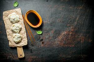 dumplings manta em uma corte borda com soja molho. foto