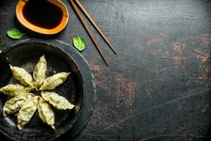 delicioso gedza dumplings dentro uma panela com soja molho. foto