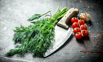 fresco aneto com faca, tomates e alho cravo. foto