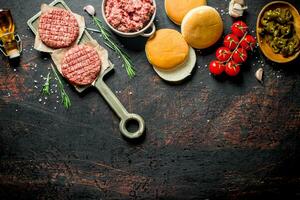 cru hambúrgueres com terra carne bovina, pães e tomates. foto