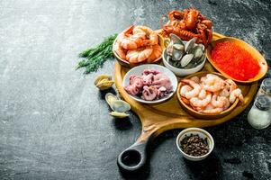 frutos do mar. camarão, lagostim, ostras, polvo e caviar dentro taças em a cortar borda. foto