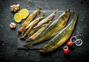 diferente tipos do defumado peixe com limão fatias, alho e tomates. foto