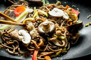delicioso chinês soba wok Macarrão com carne bovina, cogumelos e legumes. foto