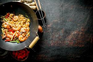 pronto chinês udon Macarrão com camarão, legumes e molho. foto
