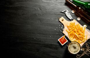 Cerveja e fritas com tomate molho em a quadro-negro. livre espaço para texto. foto