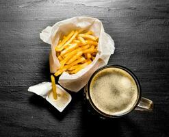 fresco Cerveja e fritas com mostarda molho em quadro-negro. foto