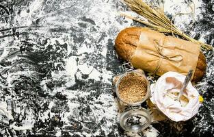 fresco ciabatta com uma saco do farinha e orelhas do trigo. foto