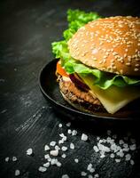 Hamburger com queijo, carne costeleta e legumes. foto