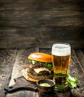 velozes Comida. uma grande hamburguer com carne e uma vidro do cerveja. foto