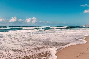 pegadas na areia da praia do Oceano Índico, ondas turquesa foto