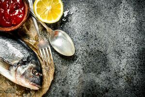 fresco despreparado dorado peixe com molho e especiarias. foto