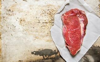 uma ampla peça do cru fresco carne em papel. foto