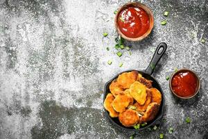 frango pepitas dentro uma fritar panela com tomate molho. foto