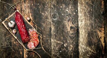 salame com ervas e especiarias em uma borda. foto