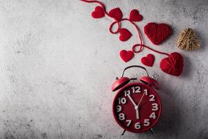 despertador vermelho com coração vermelho, conceito de dia dos namorados. foto