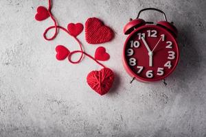 despertador vermelho com coração vermelho, conceito de dia dos namorados. foto