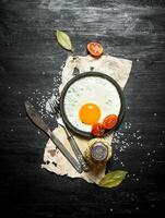 frito ovo com especiarias. em Preto de madeira fundo. foto