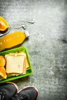 sanduíches, laranja suco e fruta. em a pedra mesa. foto